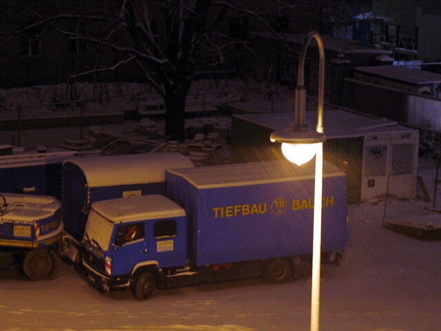 Blauer Laster an Schnee und Lampe